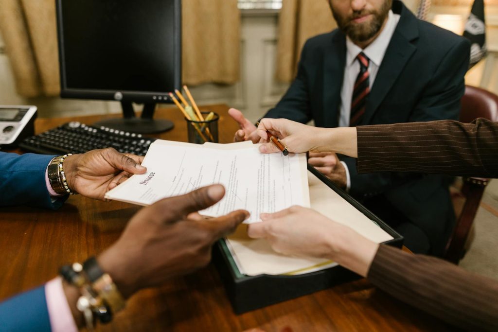 Professional meeting with individuals signing legal documents in an office setting.